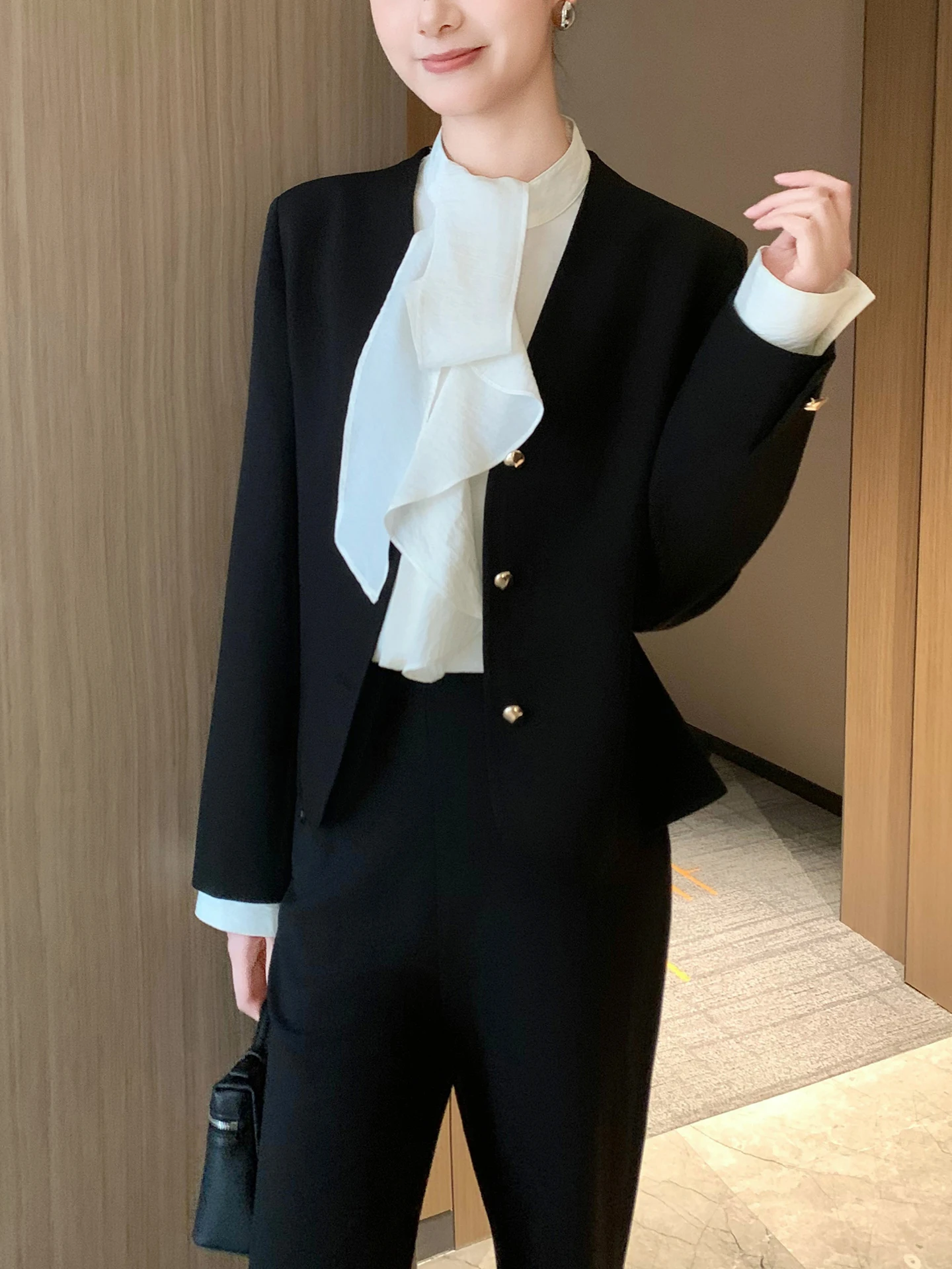 Dopasowany krój, dekolt w serek, długi rękaw, damski żakiet, czarny, z podkreśloną talią, warstwowa odzież wierzchnia, wiosna 2026, modny, uniwersalny.