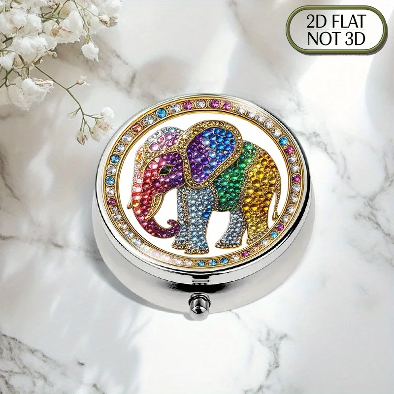 A flat, portable, round, three-compartment metal pill box, featuring a golden border and a colorful crystal elephant pattern, inlaid with sparkling gemstones and diamonds. It has a stylish and organized design for storing medication, perfect for organizing pills and storing vitamins. Flat style
