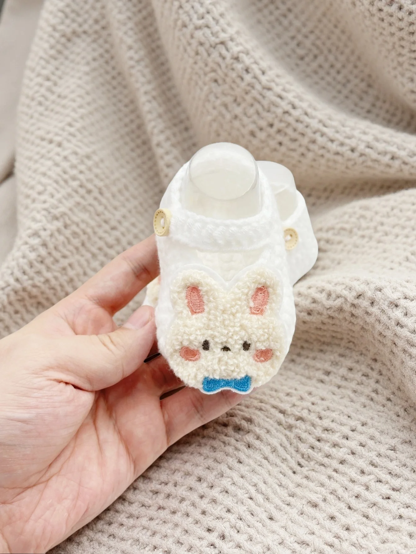 زوج واحد من أحذية الأطفال اللطيفة على شكل أرنب، أحذية شبشب محبوكة بيضاء مع فيونكة زرقاء، أحذية ناعمة للرضع مع زر إغلاق، 0-12 شهرًا