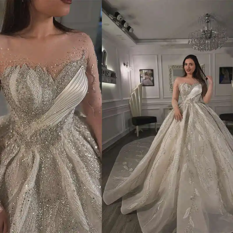 Eleganckie suknie ślubne z kryształami, prześwitujący dekolt, długi rękaw, odpinany tren, zdobione koralikami, szyte na miarę.