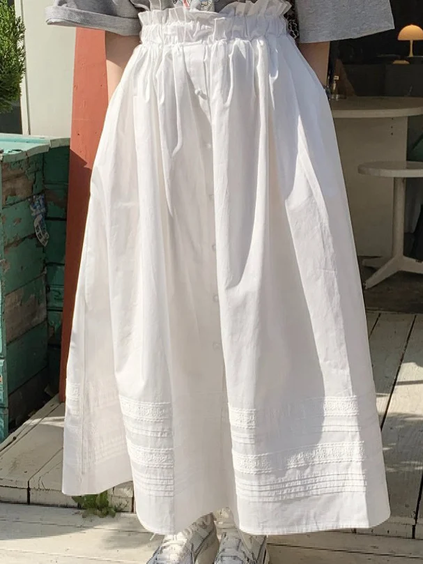 

Белая женская юбка миди А-силуэта с высокой талией, эластичным поясом, расклешенным подолом и одной пуговицей, стройнящая фигуру