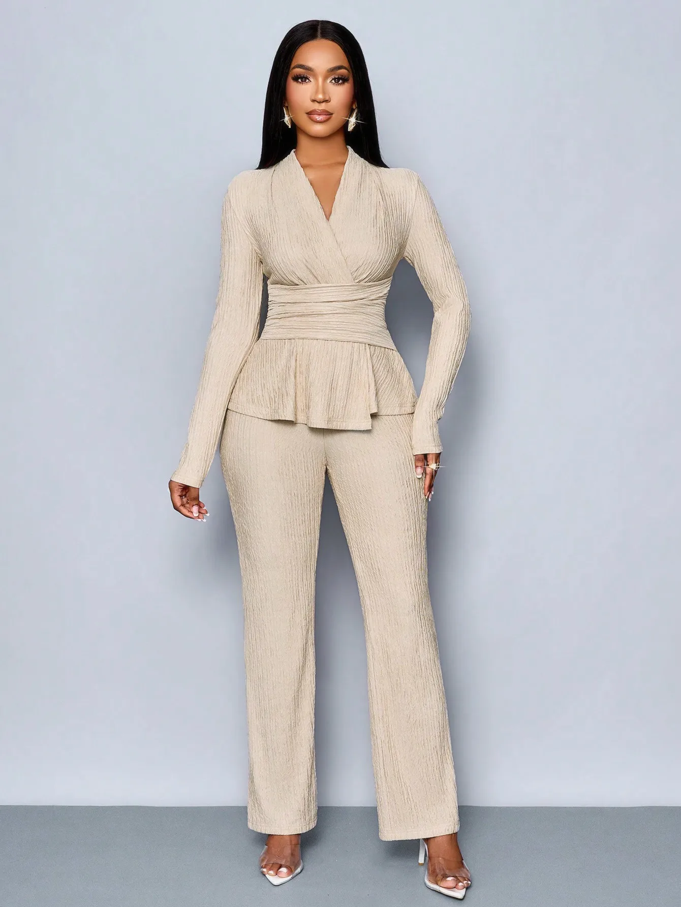 Top a maniche lunghe con scollo a V beige e pantaloni a gamba larga, completo due pezzi da donna, elegante outfit casual.