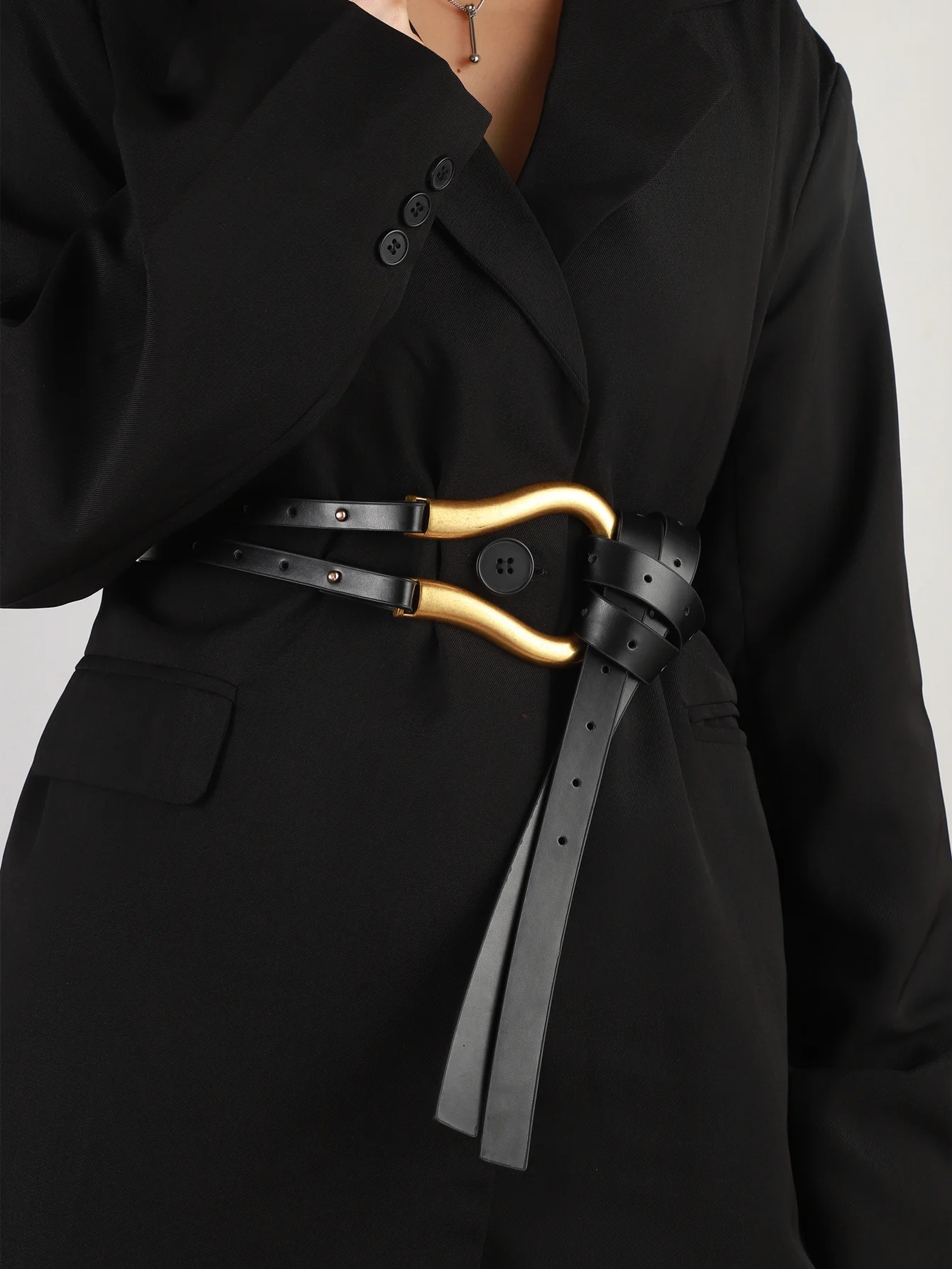 A woman\'s suit belt with a wide waistband large horseshoe button decoration with skirt belt