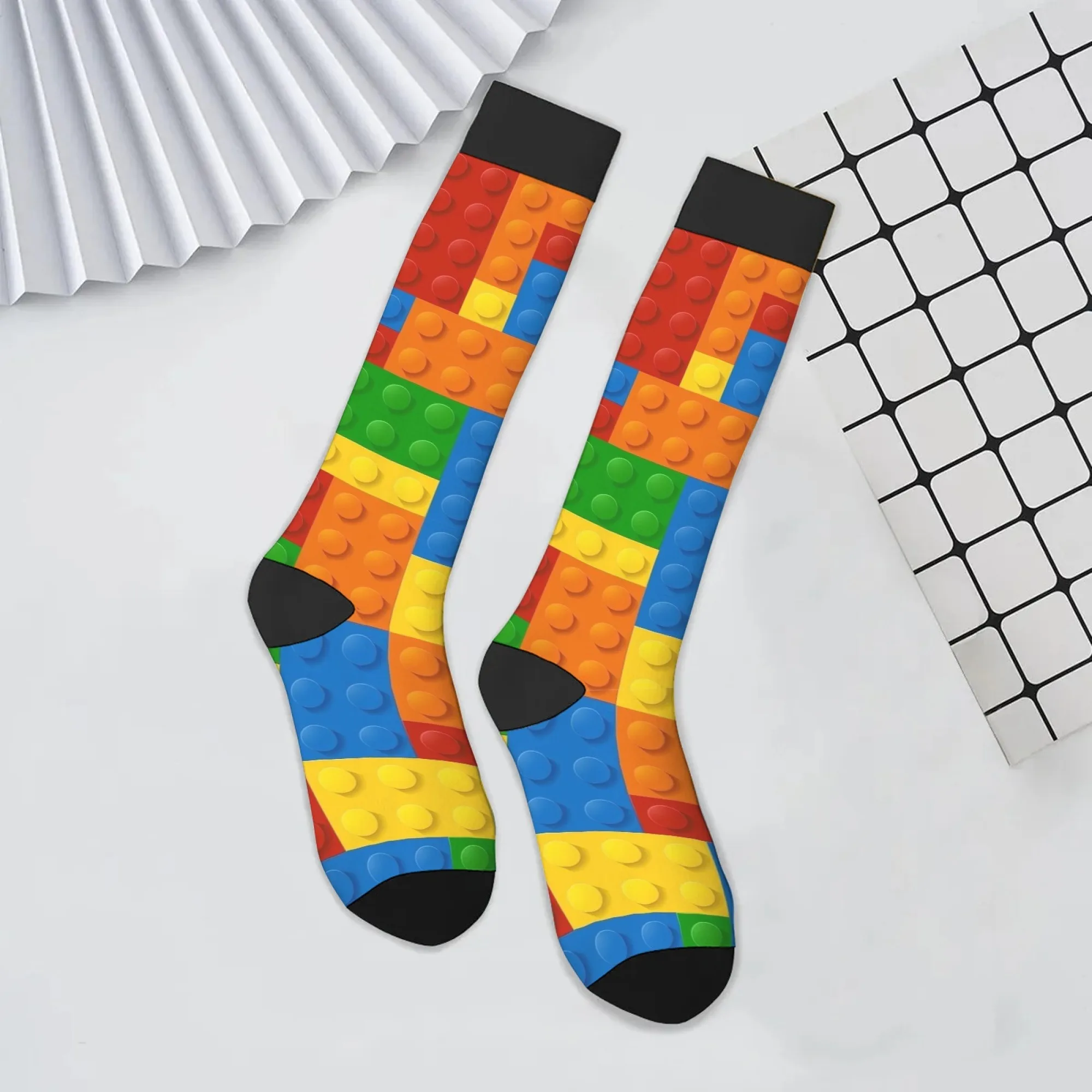 Trendige Kniestrümpfe mit Spielzeugblock-Motiv, schwarzer Grundfarbe und übergroßen Neonfarbigen Blockdetails für Street- und Outdoor-Mode.