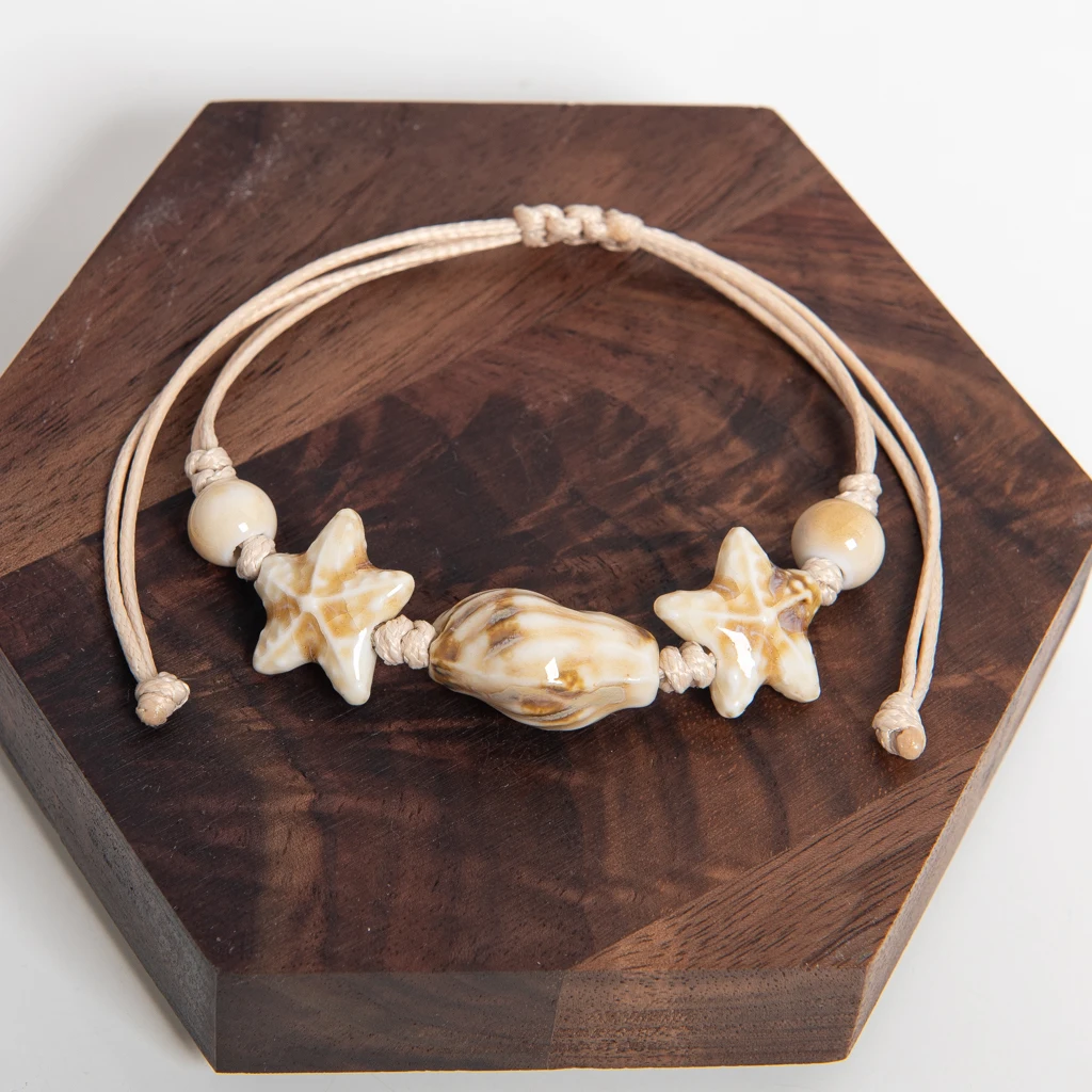 صدف من السيراميك الأبيض مصنوع يدويًا وسوار من الخرز على شكل نجمة قابل للتعديل من حبل الشمع على طراز الشاطئ الساحلي للأزواج والأصدقاء