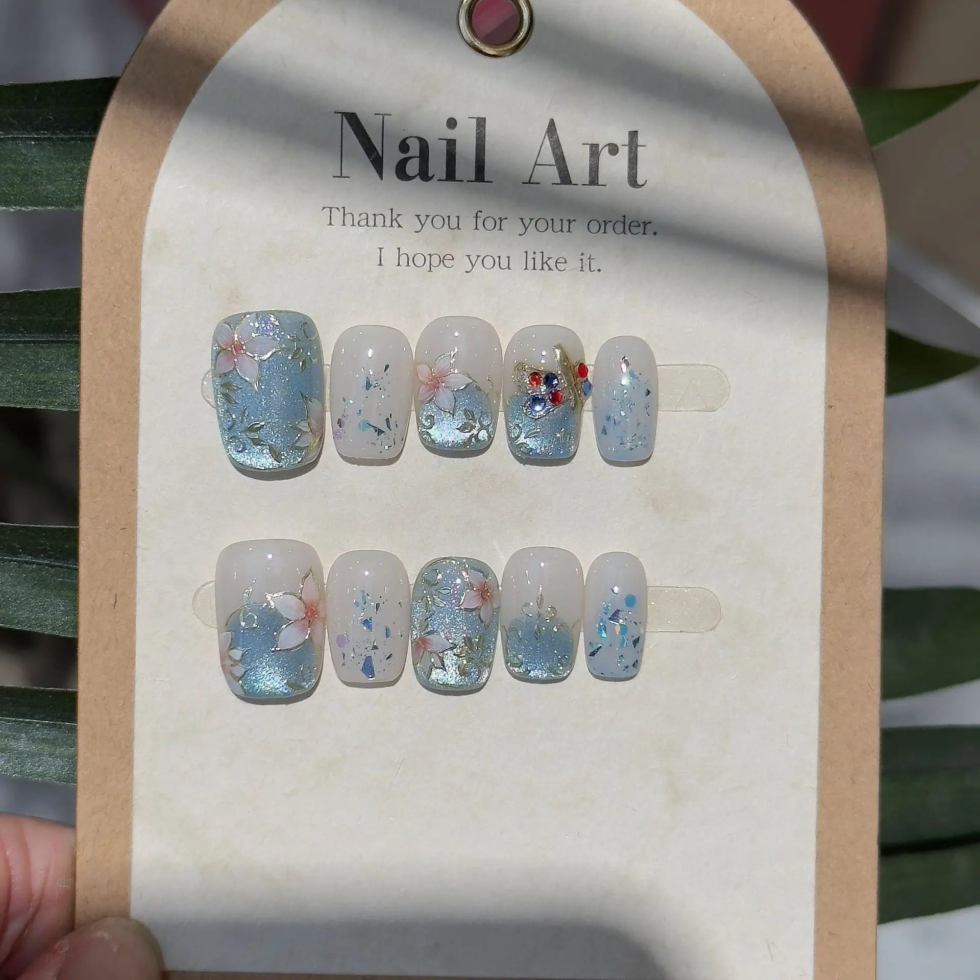 เล็บปลอมลายตาแมว 10 ชิ้น สีฟ้าอ่อน ลายดอกไม้ เล็บปลอมแบบกดติด ไล่เฉดสีกลิตเตอร์ รูปทรงโลงศพ เล็บปลอมเคลือบเงาลายดอกไม้สีฟ้าหวานๆ