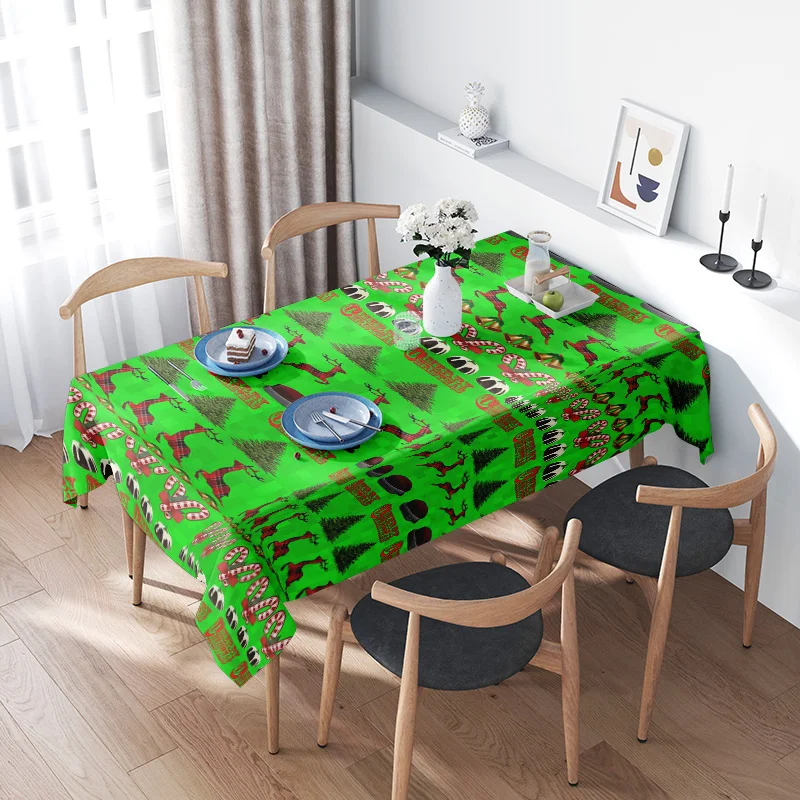 Mantel verde con temática navideña con piñones, bastones de caramelos, copos de nieve, renos y adornos de Papá Noel para comedor festivo