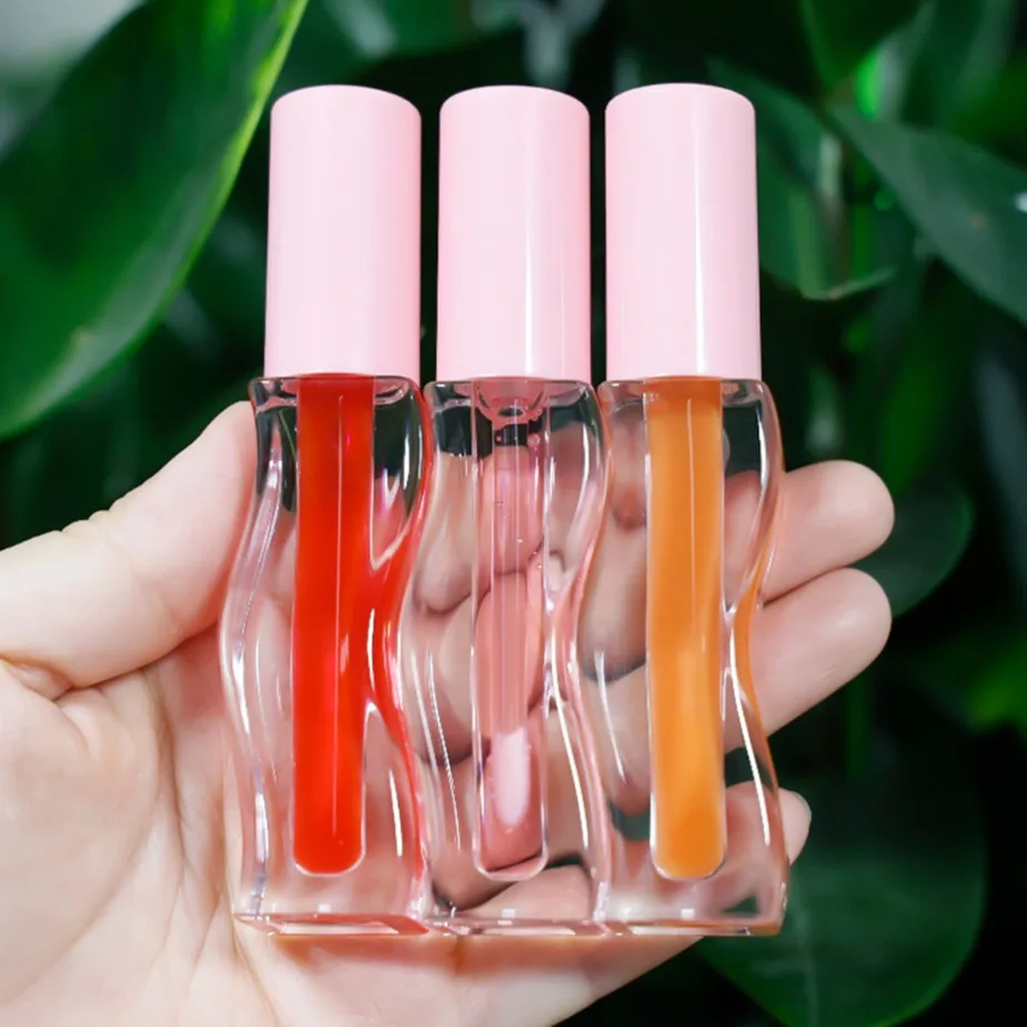Gros marque privée maquillage végétalien Logo personnalisé huile pour les lèvres fruitée repulpante conception ondulée brillant hydratant brillant Non collant brillant à lèvres