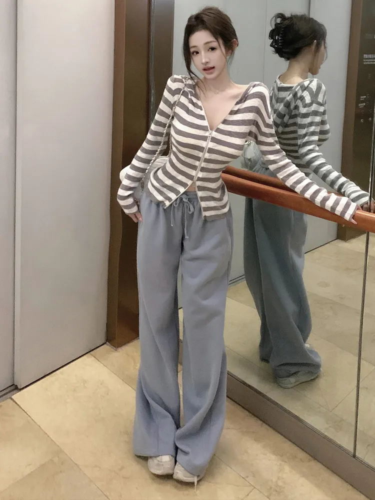 

Модный комплект из двух предметов в стиле lazy style для женщин: топ с контрастными полосками, приталенный крой, двойная молния, длинные рукава, прямые спортивные брюки.