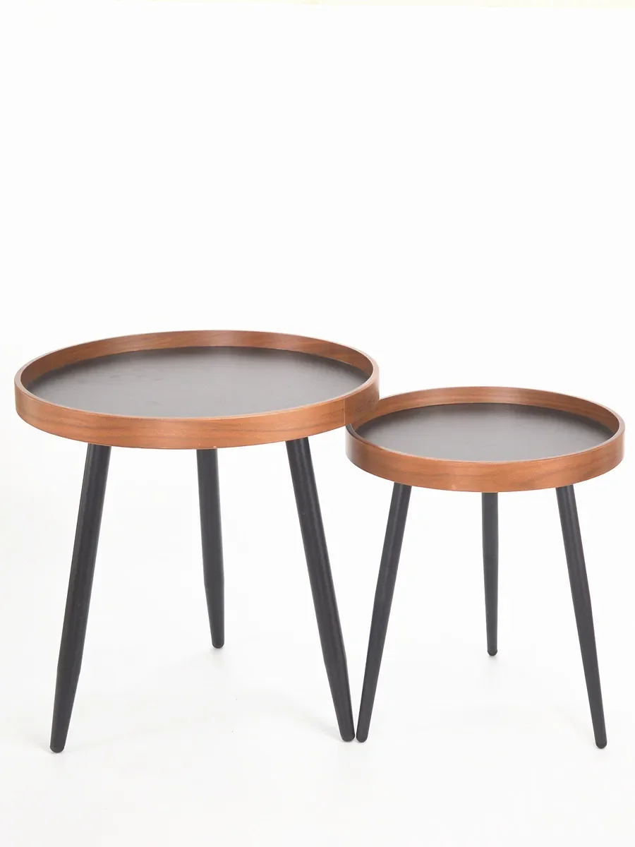 

A few round walnut-colored Nordic modern small-sized round tables in the corner of the living room at the sofa side table.