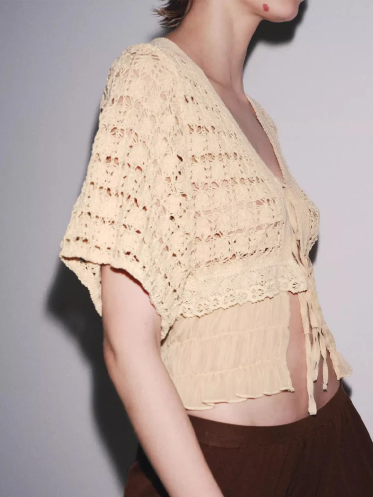 Europejskie i amerykańskie trendy jesiennej kolekcji damskiej: dzianinowy kardigan z krótkim rękawem, dekoltem w serek, sznurowaniem i łączonych elementów.