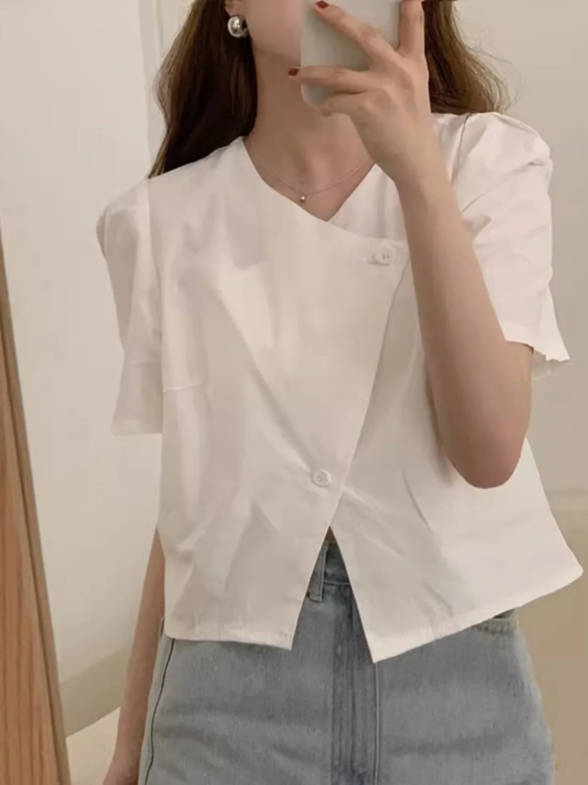 เสื้อสตรีสีขาวทรงหลวมแบบมีระบาย ดีไซน์เก๋ไก๋สำหรับฤดูร้อน คอวีแบบไม่สมมาตร ติดกระดุม ดีไซน์เรียบง่าย เหมาะสำหรับใส่ไปทำงาน สีพื้น