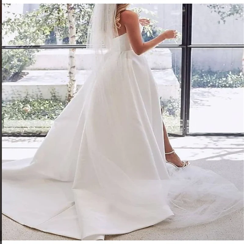 Maßgeschneiderte Falten-Prinzessin-weiße Brautkleider 2026 für die Braut, trägerloses, ärmelloses Damen-Ball-Brautkleid aus Satin mit Schleppe