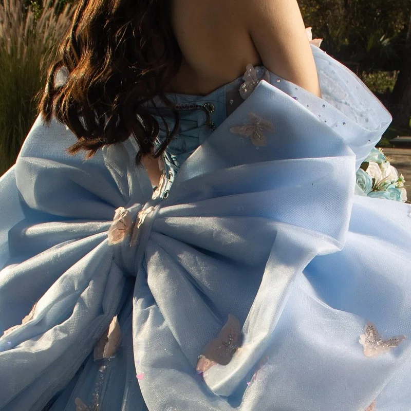 فستان Quinceanera باللون الأزرق المائي اللامع عاري الكتفين مزين بالترتر بفيونكة كبيرة وذيل طويل فيستدوس دي 15 Quinceanera ﻿ تخصيص
