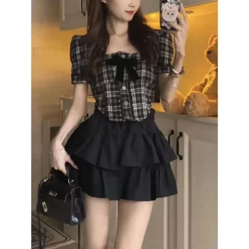 Novedad de verano, ropa de té pequeña a la moda, camisa de manga de burbuja a cuadros, Falda corta de pastel negro, traje pequeño de dos piezas de viento fragante para mujer