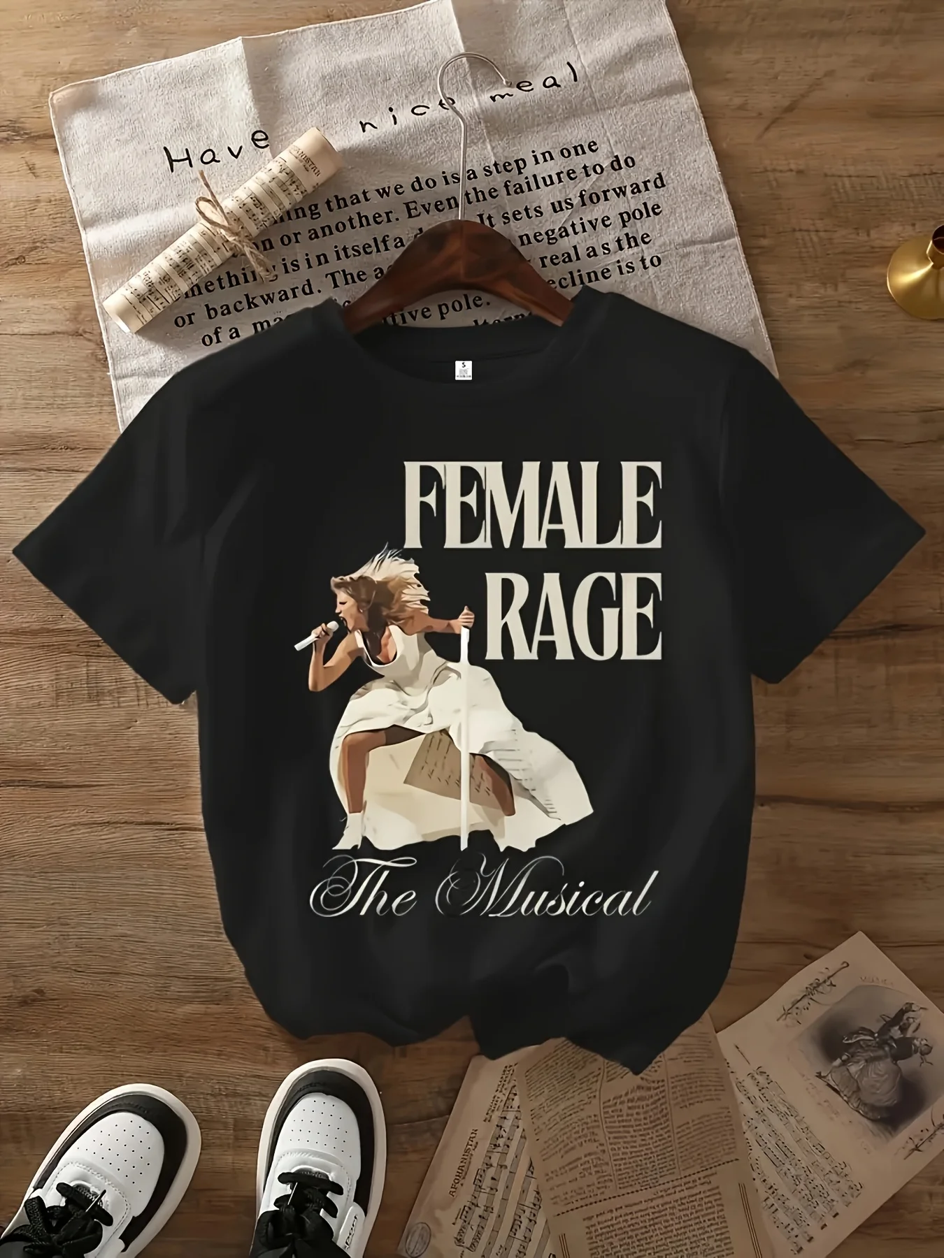 

Женская футболка с рисунком «Женский радж» — черная повседневная футболка с круглым вырезом и белыми надписями и музыкальной тематикой,