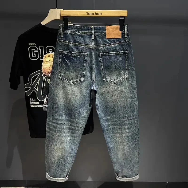 メンズ向けハイエンドダメージパッチ生地ハーレムパンツ、頑丈でハンサムなルーズストレートデニムパンツ、トレンドのテーパードパンツ、お父さん向け