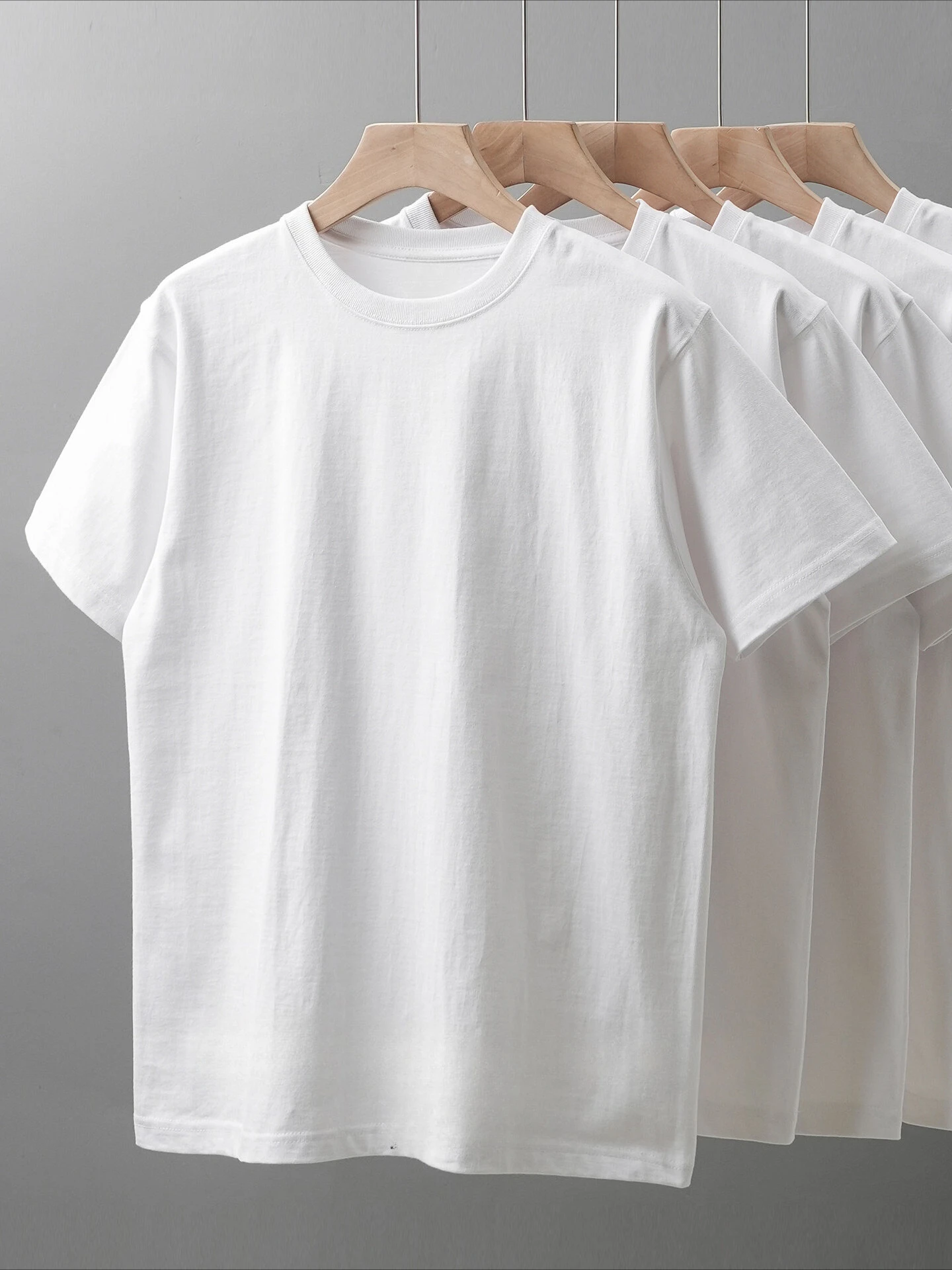 A solid-color T-shirt suitable for all seasons—a versatile layering piece with a relaxed, clean, and casual fit.