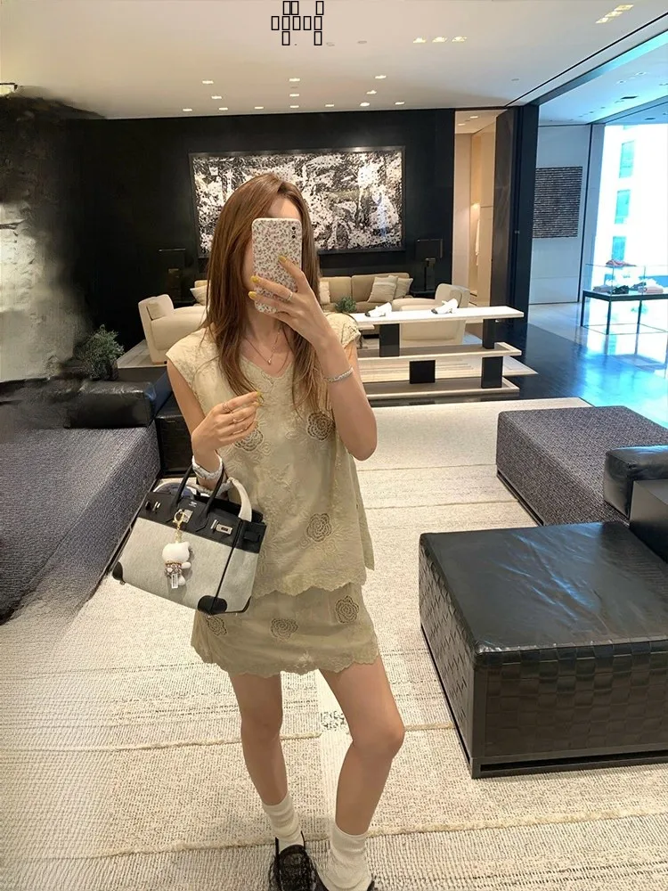 

Женский модный хлопковый костюм из двух предметов: топ с V-образным вырезом и лазерной перфорацией Ranwear и короткая юбка с эластичной талией.