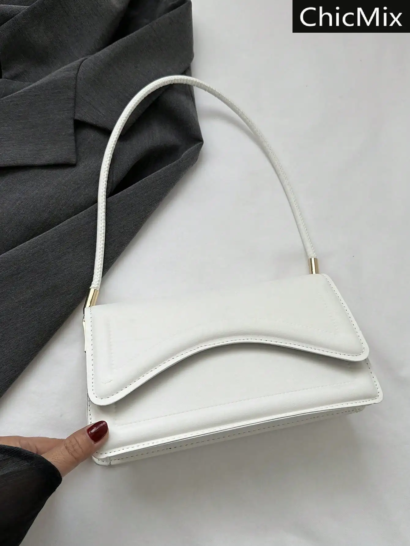 

Минималистичная белая сумка-конверт с ручкой и золотистой фурнитурой