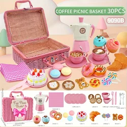 The little girl pretends to play with a picnic basket, tea party set, tea set including coffee machine, cookies, cake, game food
