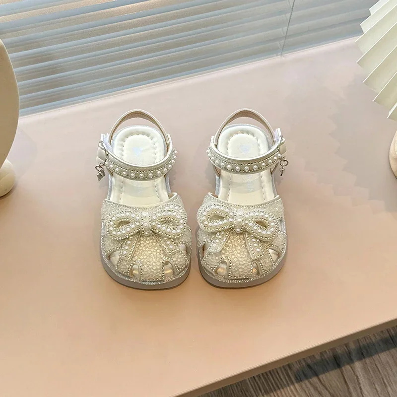 Sandalias planas elegantes para niñas, chanclas con lazo de perlas para niños, sandalias de princesa informales con diamantes de imitación, recortes de moda, sandalias de vestir para niños