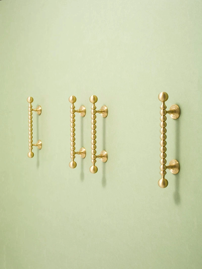 Different lengths of beaded brass pulls shown upright