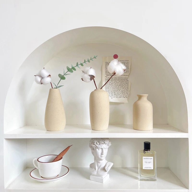 White shelf with ceramic vases and a sculpture