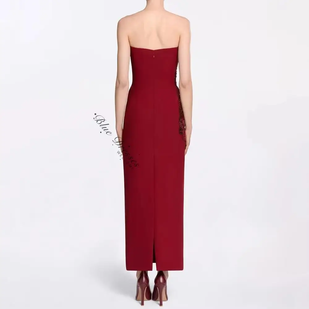 customized Burgundy strapless long gown with front floral ornament. Figure-hugging cut presents grace, elegant design embodies n