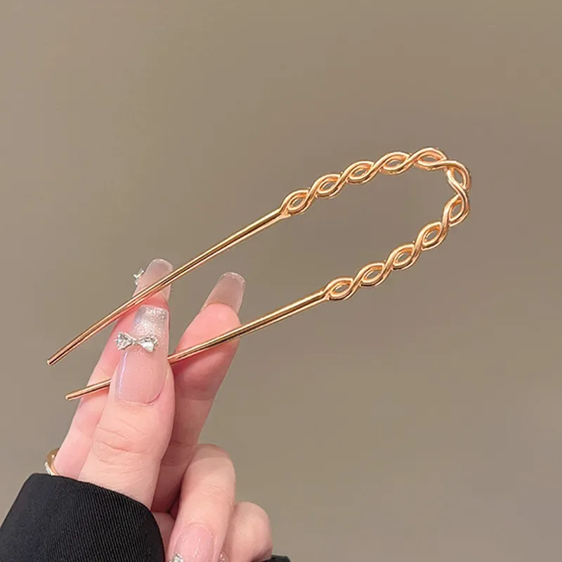 금속 참 장식의 꼬임 패턴과 매끄러운 교차로 엮인 U자형 브로치가 세련된 드레싱 스타일을 빛내며, 독특하면서도 고급스러운 느낌을 선사합니다.