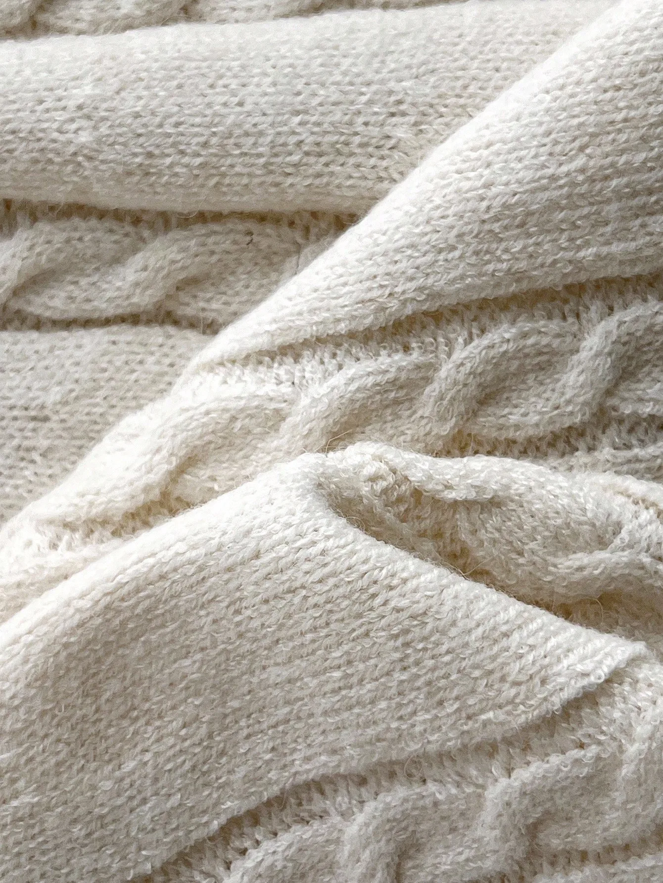 Damska kremowa sukienka swetrowa z długim rękawem, z kołnierzykiem polo, dzianiną w warkocze i czarnymi wykończeniami.