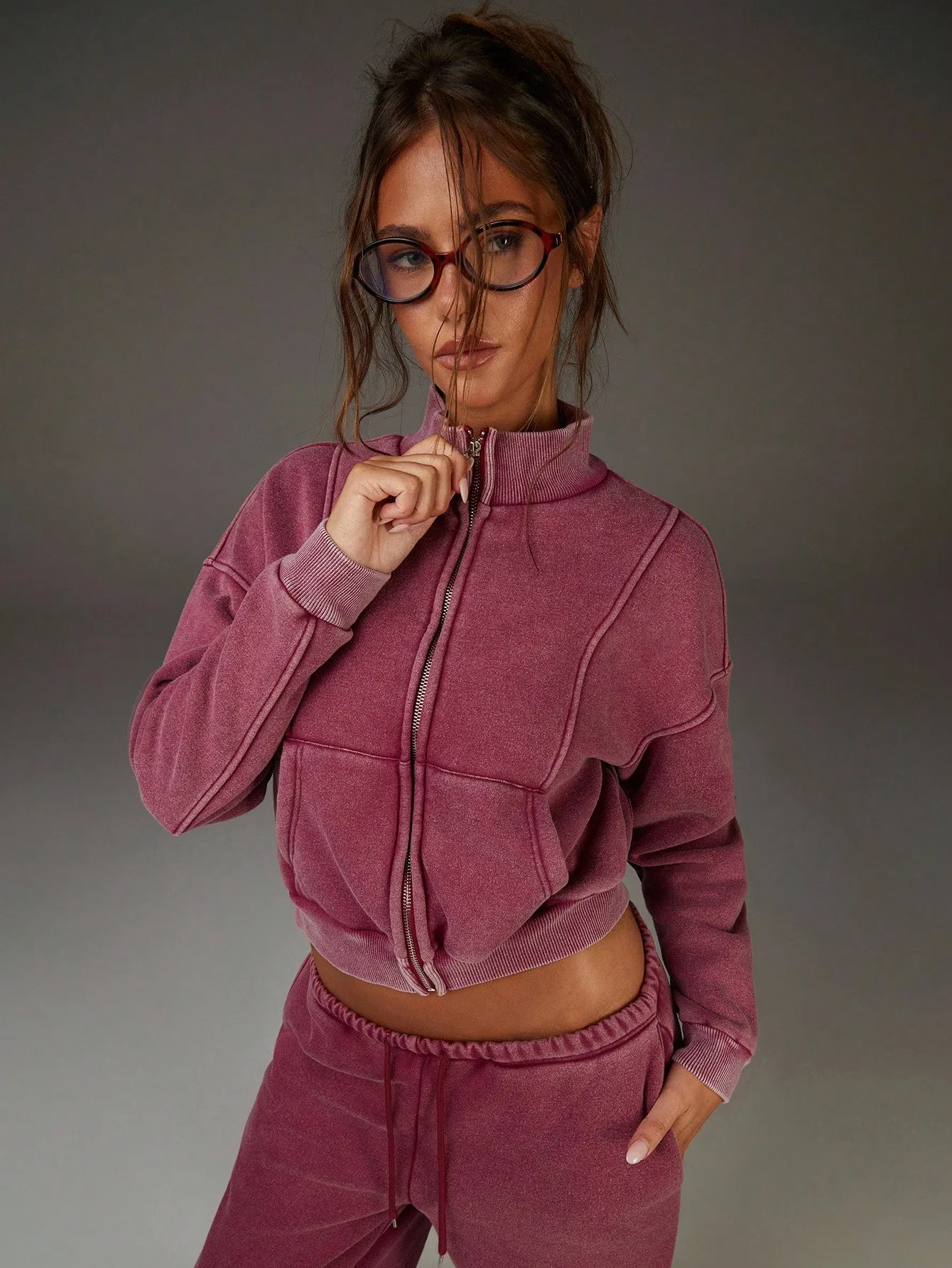 Damska kurtka w kolorze magenta, w stylu vintage, z prążkowanym materiałem, zapinana na zamek, z ozdobnymi przeszyciami, krótka, idealna do codziennego streetwearu.