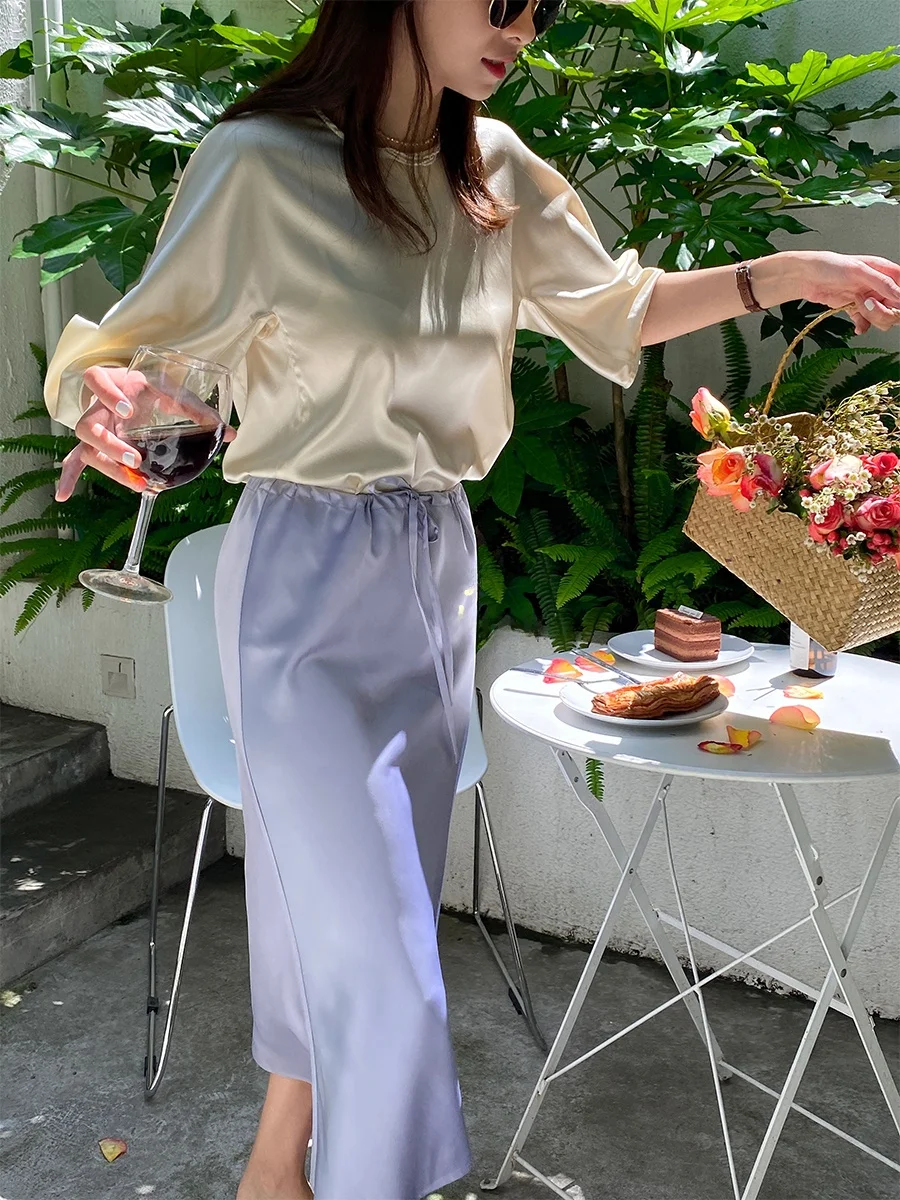 

Летний комплект из двух предметов: шелковая атласная футболка с коротким рукавом и брюки с широкими штанинами. Модный элегантный женский костюм.