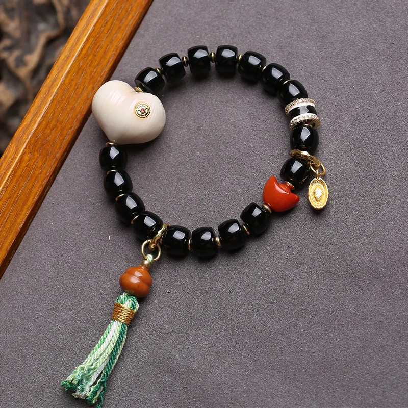 Natural black agate bracelet with barrel beads, reverse-flow bone, peace knot, ivory fruit, peach, monkey head and bodhi seeds - view 5