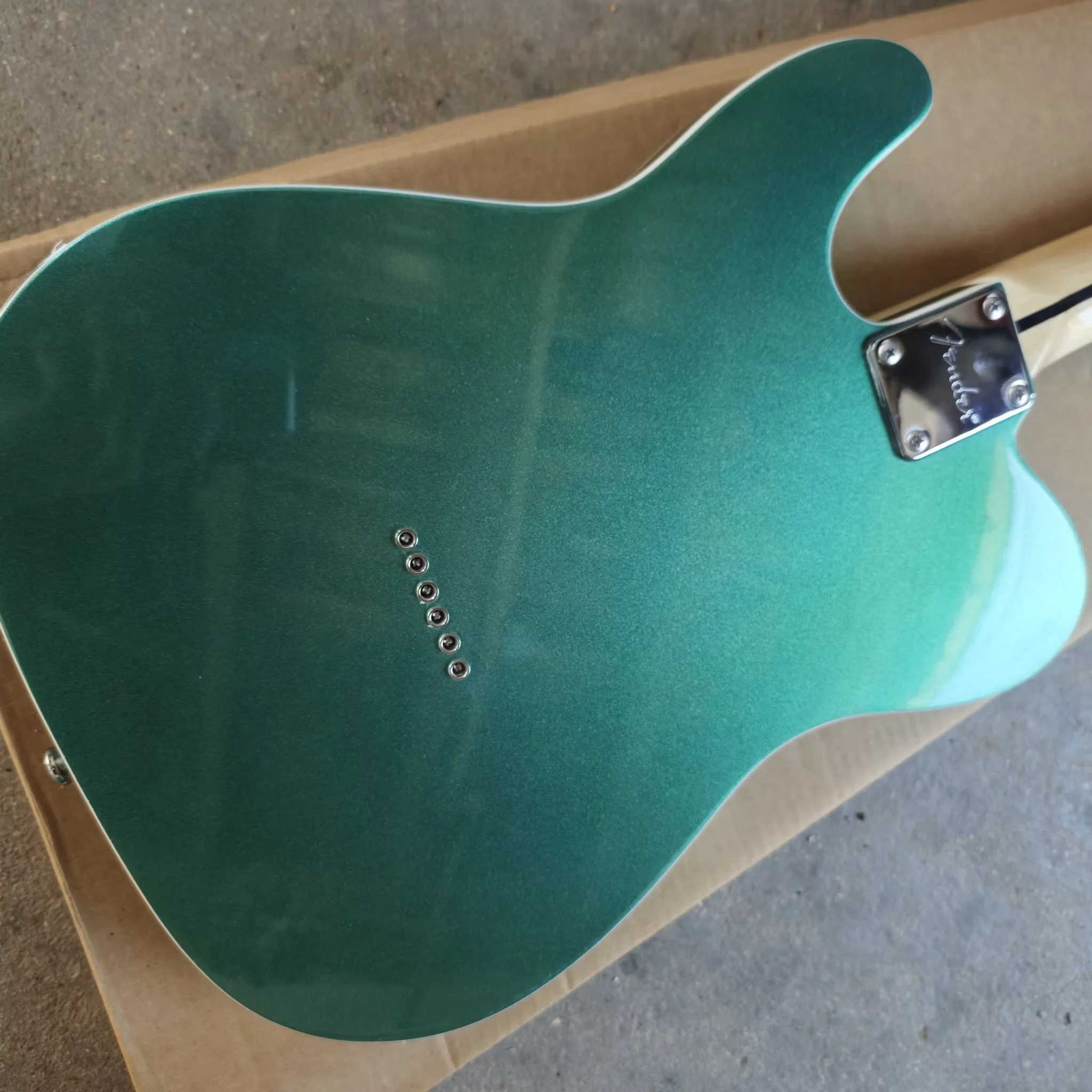 Six string electric guitar with white edging, green silver powder paint finish, black protective plate