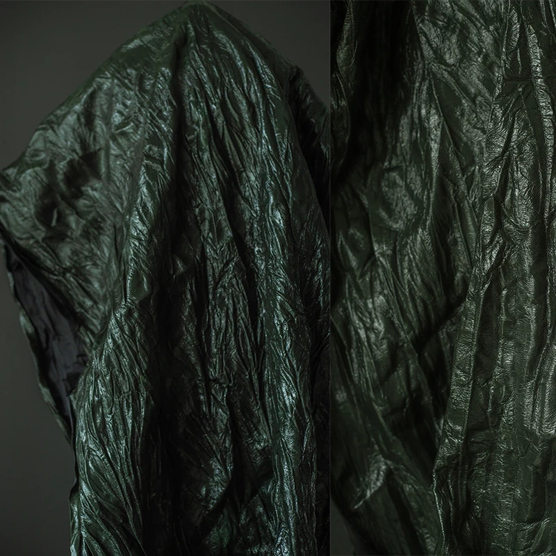 Tela de cuero italiano encerado de color verde oliva, con textura, arrugas verticales, rígida, que cambia de color, material para chaquetas de diseño.
