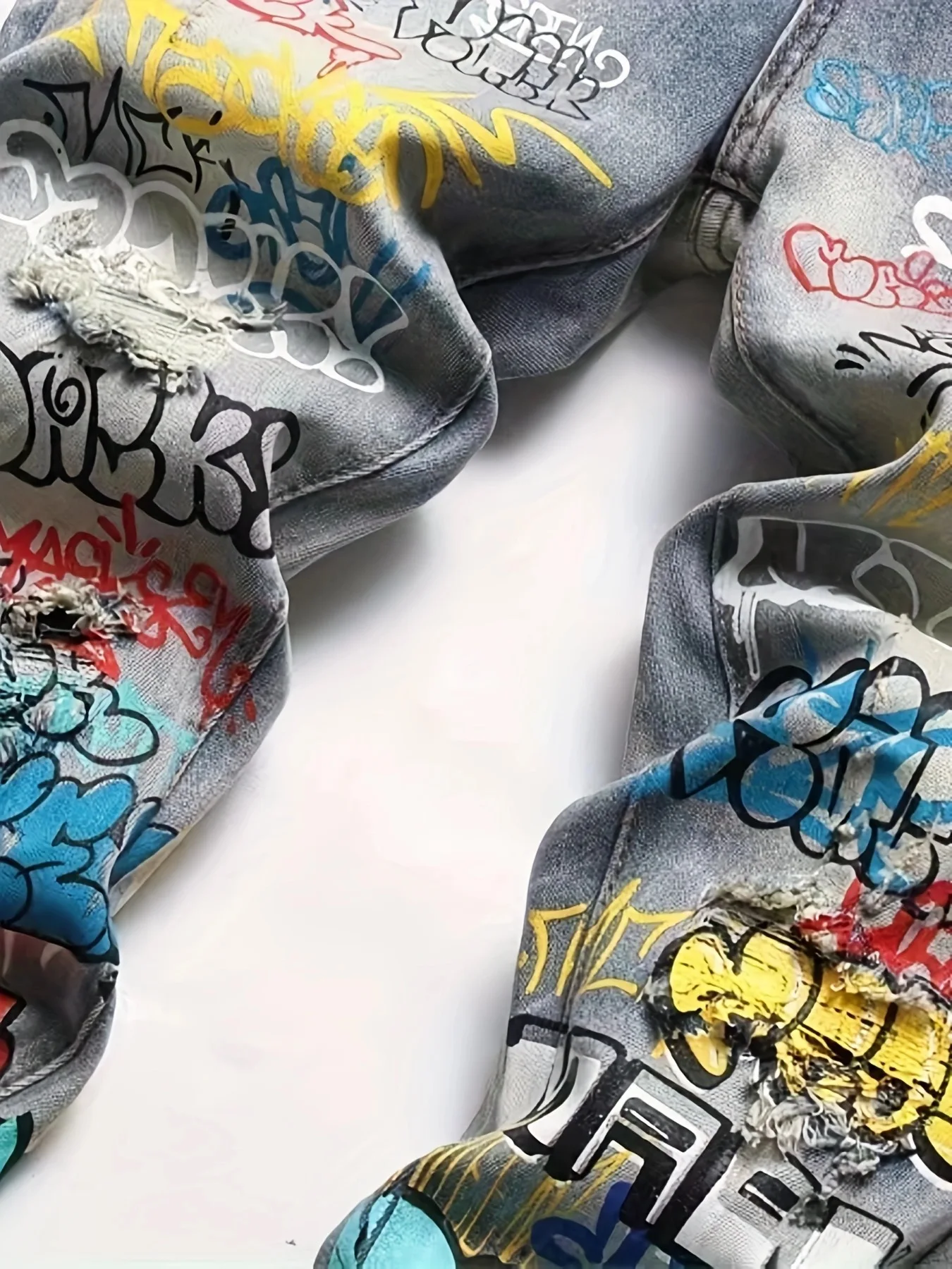 Vecchi jeans lavati e strappati con graffiti stampati europei e americani