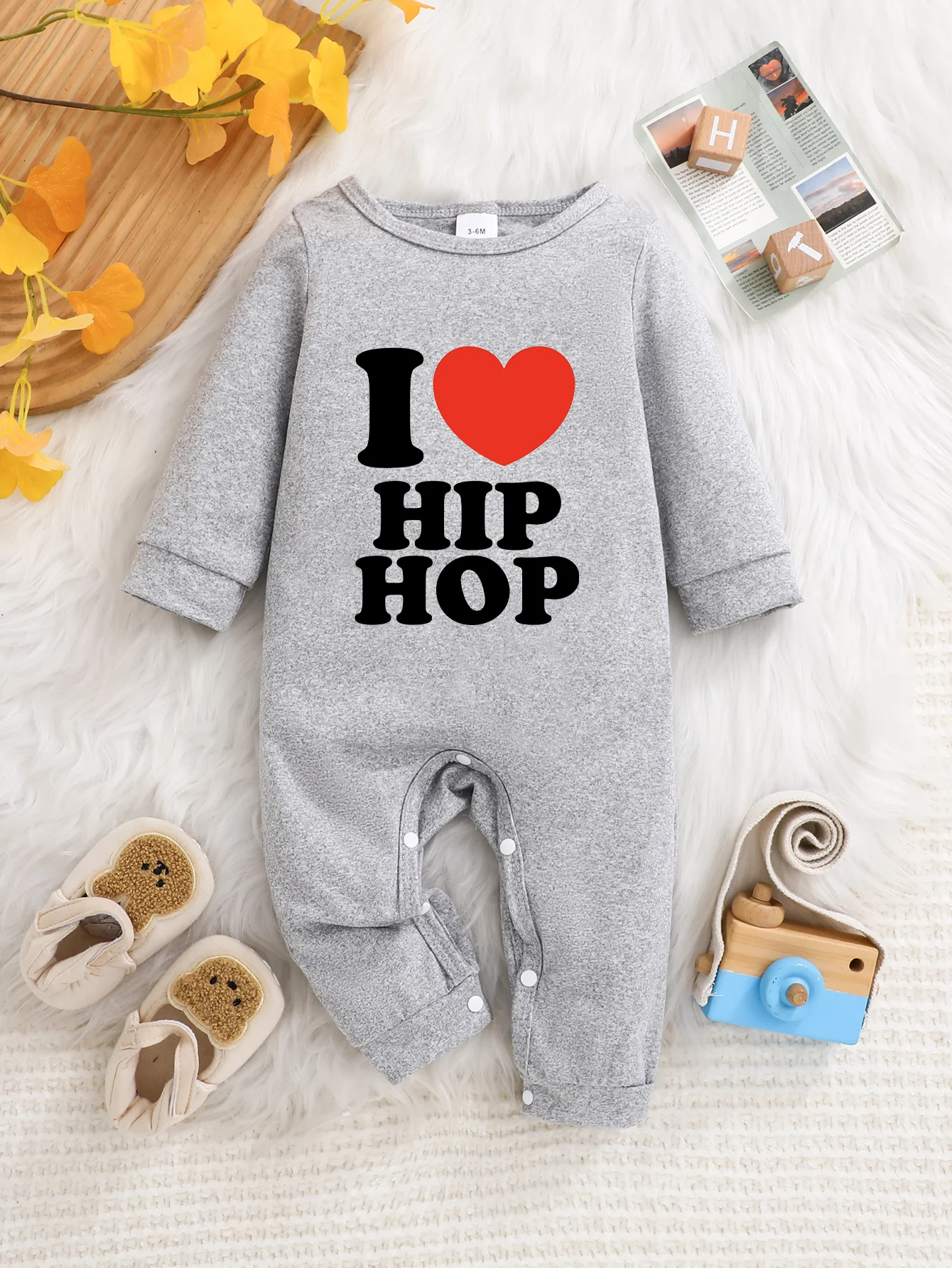 

A baby long-sleeved onesie with interesting letter prints. It features a buttoned design for easy putting on and taking off