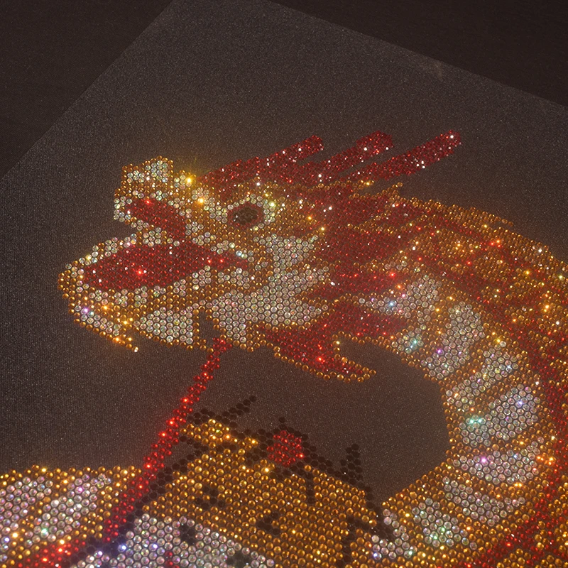 The shiny rhinestone cartoon dragon dance pattern is ironed on sweaters, coats and clothing accessories