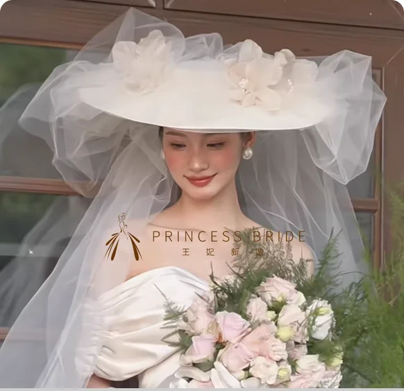 

New elegant French flower bridal top hat with yarn on location, wedding dress and studio accessories.