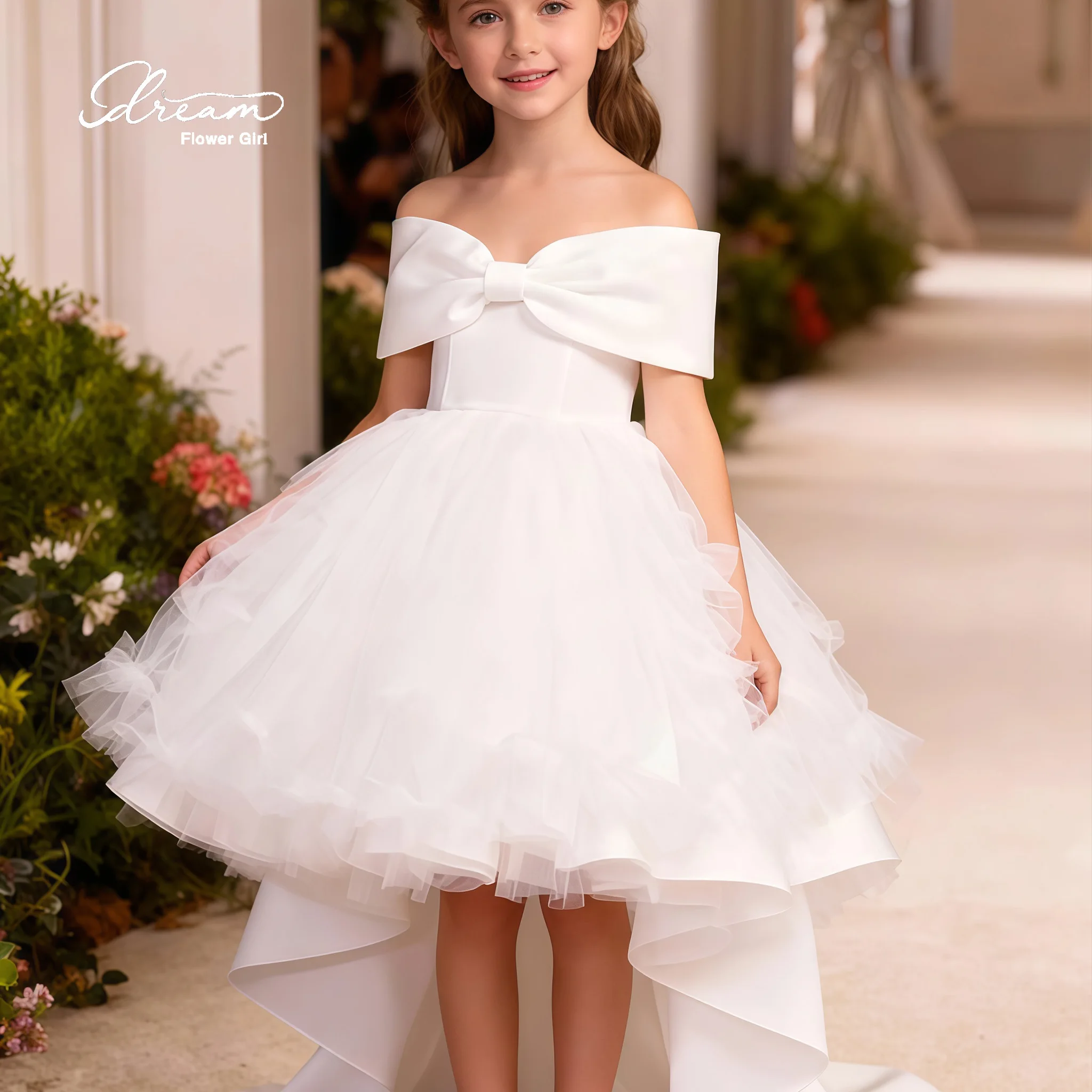 Girls' white formal ball gown featuring an off-the-shoulder V-neck sleeveless design voluminous skirt bow detail and open back