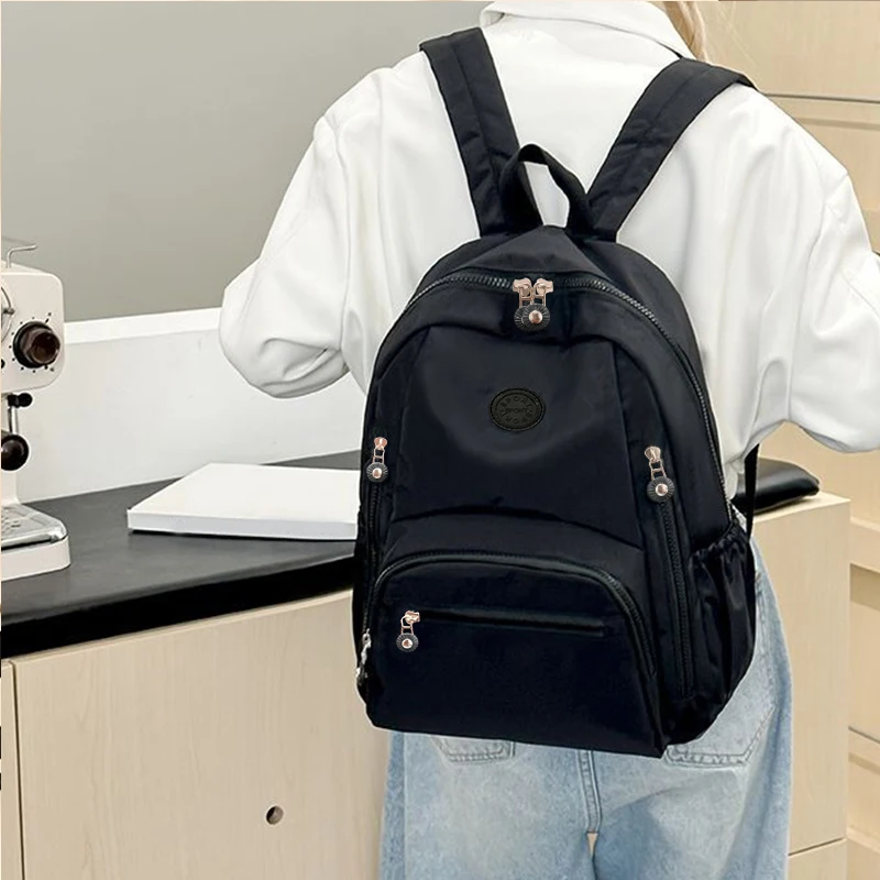 حقيبة ظهر للسفر للرجال والنساء ذات طراز محايد باللون الأسود بسعة كبيرة. تصميم بسيط، مناسب للحقائب المدرسية.