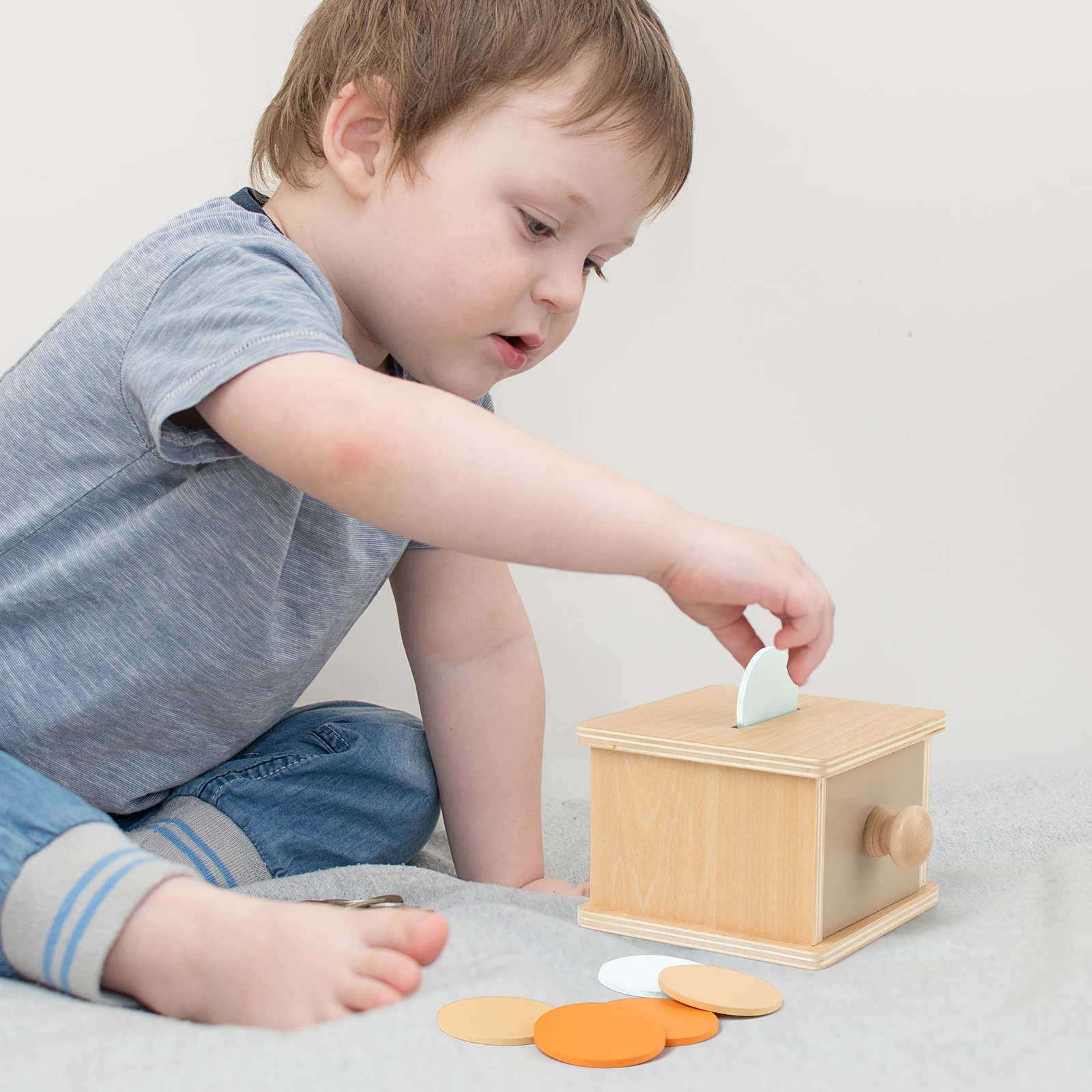 Jouet de tiroir de forme circulaire en bois. Des disques colorés glissent en dehors, offrant des bébés une expérience de jeu pratique délicieuse