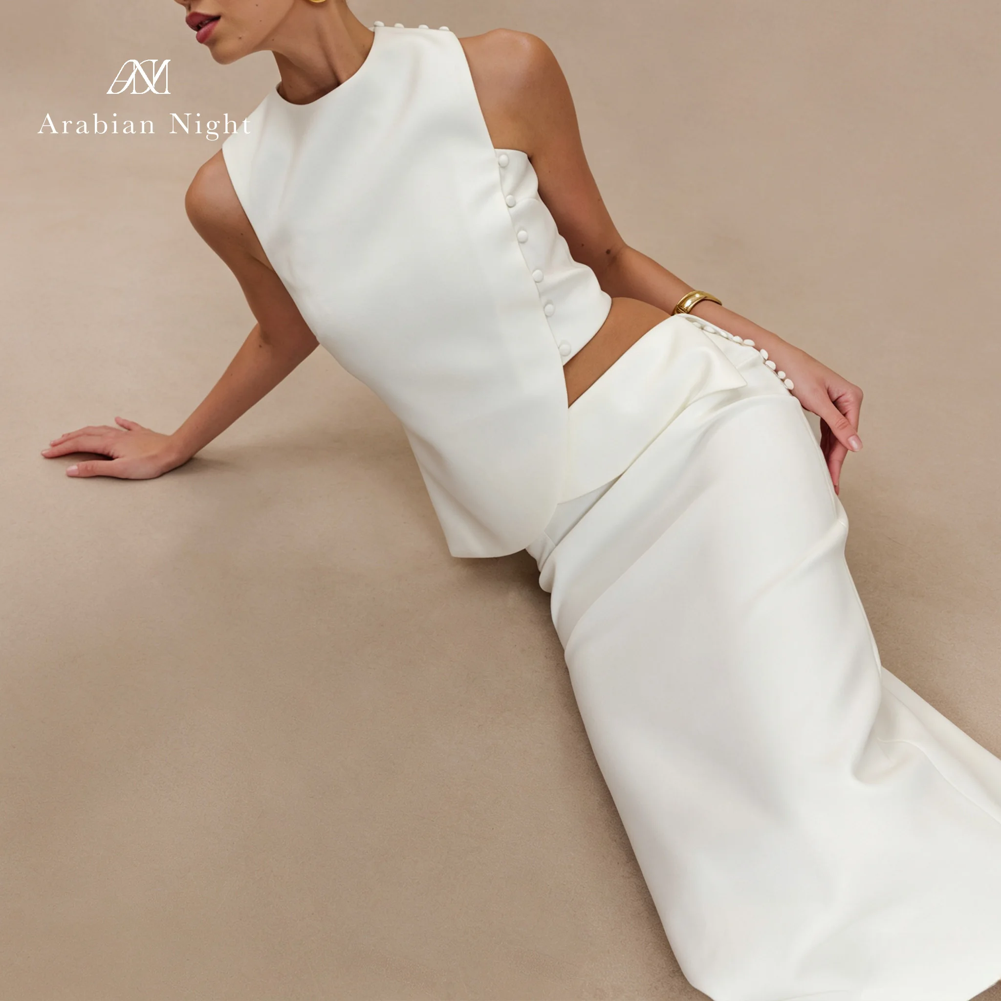 IIvory white round-neck sleeveless floor-length formal ball gown with fish tail design, exposing the midriff through the buttons