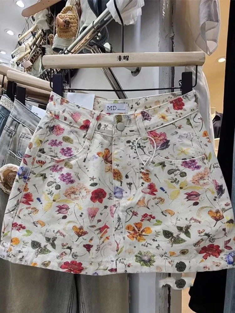 تنورة قصيرة من قماش الدنيم مطبوعة بالزهور البيضاء للنساء في الصيف من تنورة حلوة وعالية الخصر لتنحيف الخصر وتعانق الورك