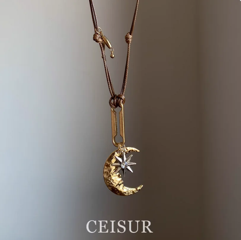 

Vintage crescent moon and star pendant necklace with adjustable wax cord, versatile and perfect for pairing with sweaters in aut