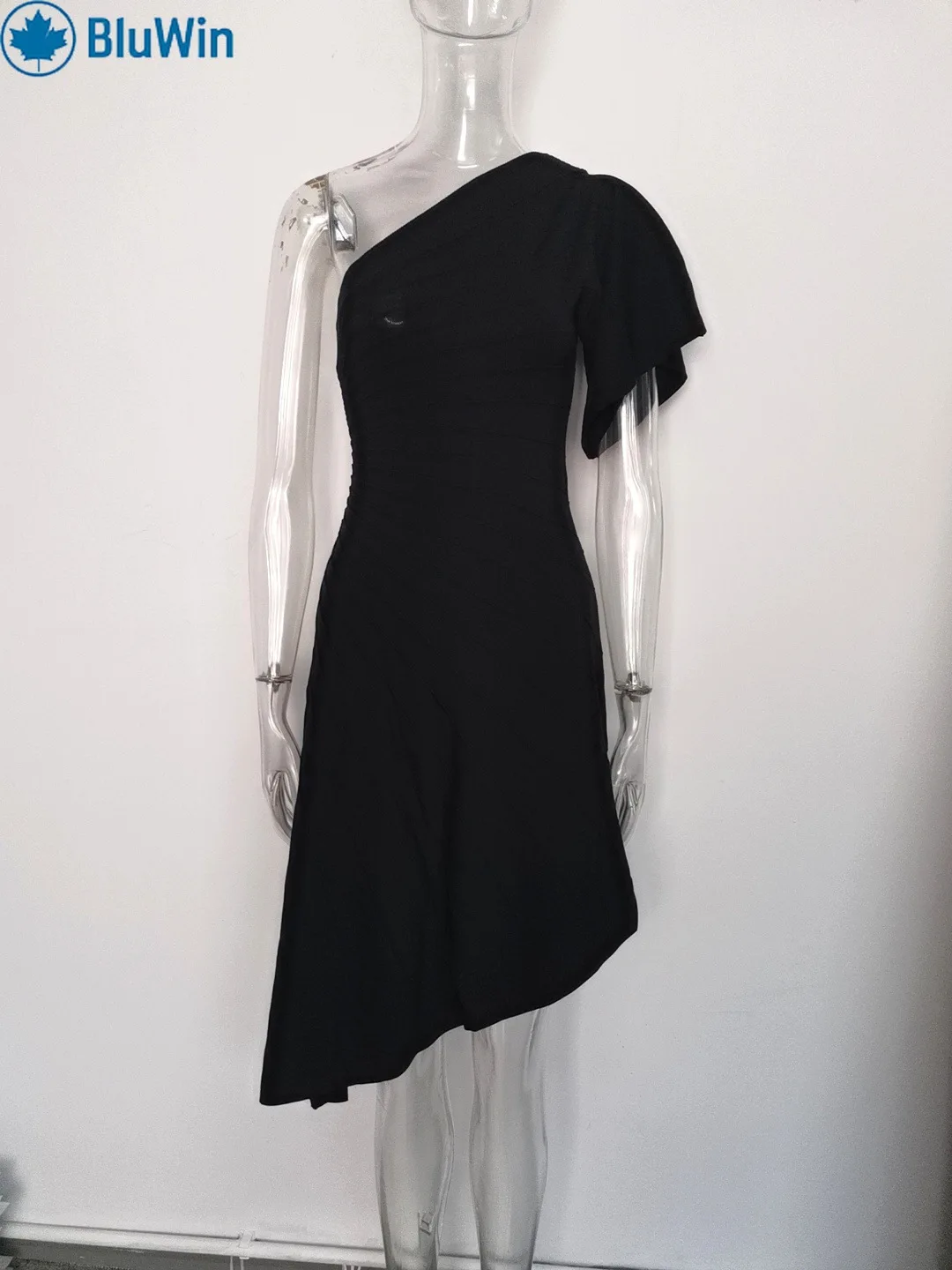 เดรสไหมพรมแขนกระดิ่งเปิดไหล่ทรงเข้ารูป ดีไซน์ชายเสื้อไม่สมมาตร แต่งระบายแนวเฉียง ช่วยเน้นสัดส่วนช่วงเอว