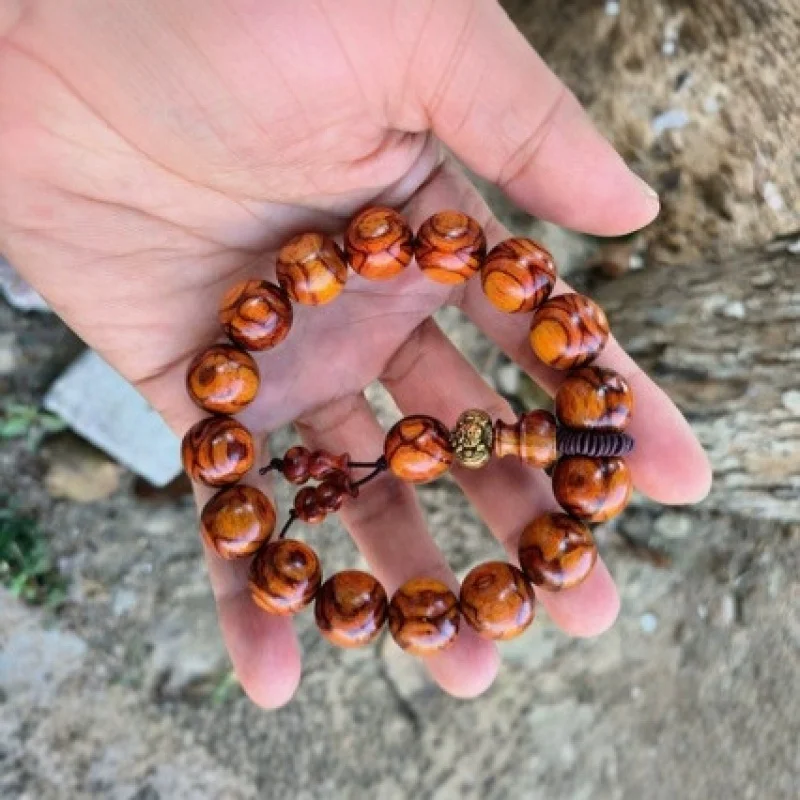 The Hainan Huanghuali 15-bead bracelet can be worn, featuring a golden background pattern with ghost faces eye motifs, and f