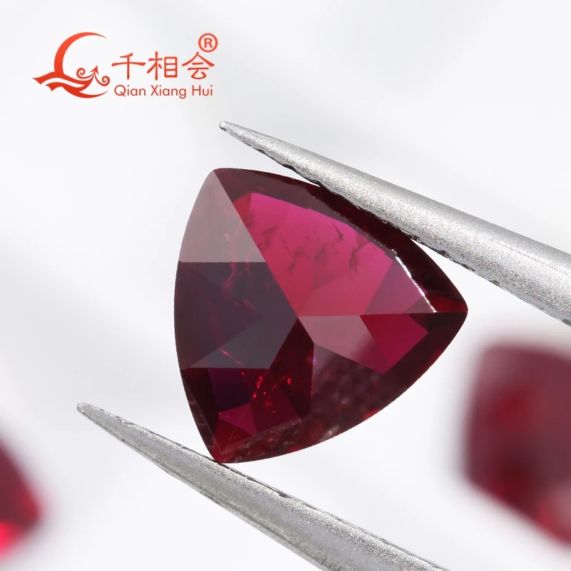 

Натуральный рубин глубокого красного цвета, выращенный в лаборатории, в форме триллиона, с незначительными трещинами и включениями