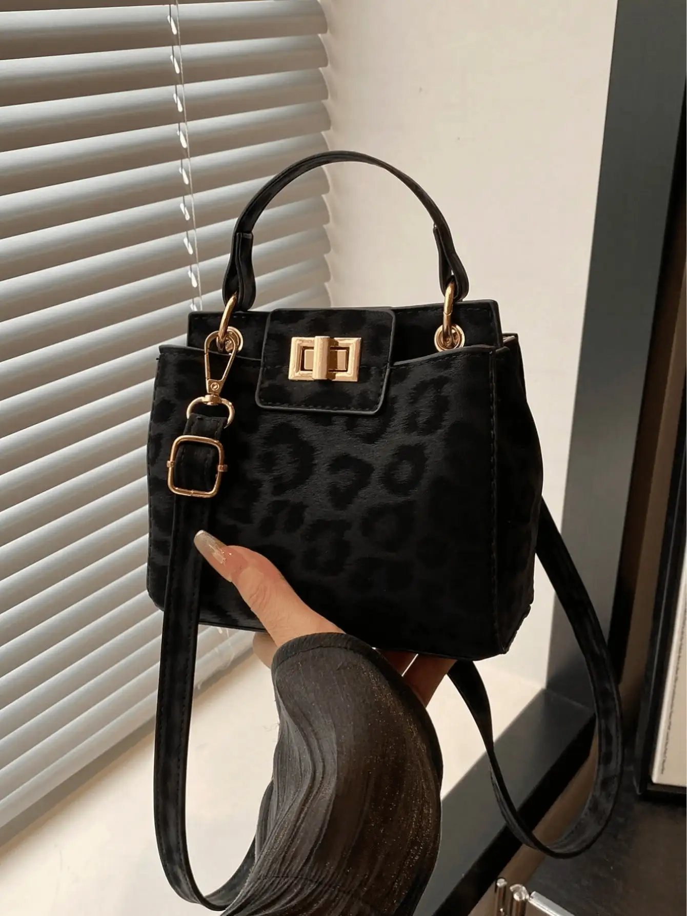 

Черная сумка с леопардовым принтом, золотой застежкой и регулируемым ремешком